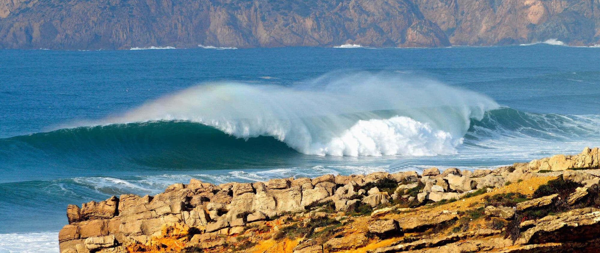 Onda perfeita a rebentar na Praia do Guincho, com a Serra de Sintra ao fundo